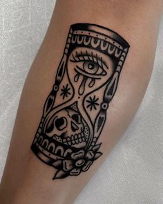 a black and white tattoo with an hourglass in the middle on someone's leg