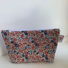 a small floral print purse on a white table