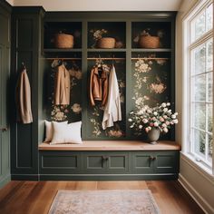 a room filled with lots of green cabinets next to a flower vase and coat rack