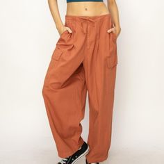 The Drawstring Cargo Wide Leg Pants Are A Trendy And Functional Addition To Your Wardrobe. The Drawstring Waist Allows For A Customizable And Comfortable Fit, While The Cargo Pockets Add A Touch Of Utility And Style. The Wide-Leg Silhouette Adds A Relaxed And Effortlessly Chic Vibe, Making These Pants A Versatile Option For Both Casual And Dressed-Up Looks. Features: Basic Style Sheer: Opaque Material Composition: 100% Cotton Care Instructions: Machine Wash Cold. Tumble Dry Low. Imported Product Baggy Utility Pants For Loungewear, Baggy Utility Bottoms For Loungewear, Relaxed High Waist Pants With Pockets, Relaxed High-waist Pants With Pockets, Utility Style Drawstring Pants For Loungewear, Utility Drawstring Pants For Loungewear, High Waist Parachute Pants With Relaxed Fit For Loungewear, Casual High Waist Parachute Pants For Loungewear, Relaxed Baggy Drawstring Bottoms