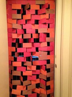 a door decorated with orange and pink paper squares in the shape of rectangles