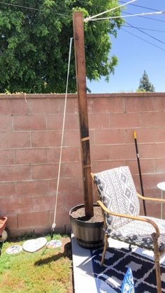 a chair sitting on top of a grass covered field next to a brick wall and power lines