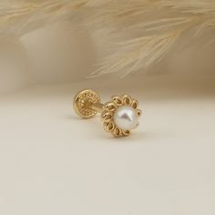 a pair of gold earrings with white pearls