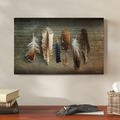 a wooden table topped with lots of different types of feathers