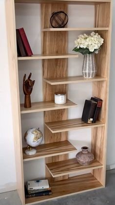 a wooden shelf with books and vases on it