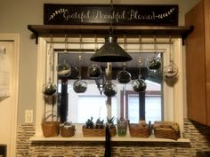 a kitchen window with pots and pans hanging from it