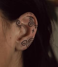 a woman's ear with tattoos on it