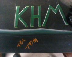 the back end of a black chair with khm written on it