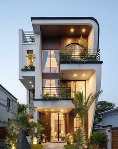 a modern house with lots of windows and balconies on the second floor is lit up at night