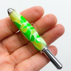 a hand holding a green and white pen in it's left palm, with the tip extended