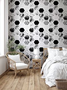 a bed room with a neatly made bed and a wallpapered pattern on the wall