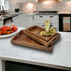 two serving trays with grapes and wine on a kitchen counter