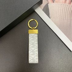 a keychain that is sitting on top of a black table next to a photo