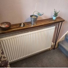 a radiator with some plants on top of it next to a stair case