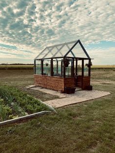 a small greenhouse in the middle of a field