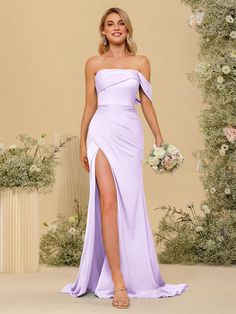 a woman in a lavender colored dress with one leg slited up and holding a bouquet