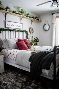 a bedroom decorated for christmas with wreaths and garland on the wall above the bed