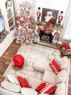 a living room decorated for christmas with red and white decorations on the fireplace mantel