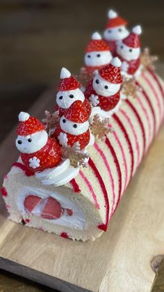 a piece of cake decorated with strawberries and santa clause hats on top of it