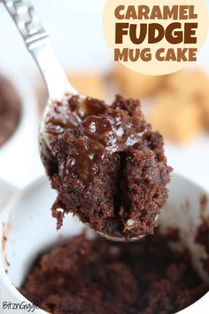 a spoon full of chocolate fudge cake with the words, caramel fudge mug cake above it