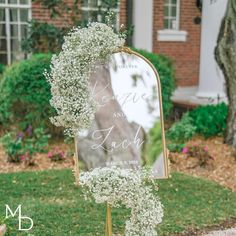 a wedding sign with baby's breath in front of a house