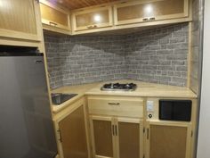 a small kitchen with wooden cabinets and silver appliances