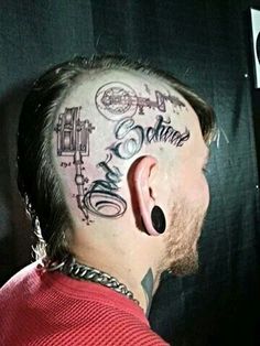 a man with tattoos and piercings on his head