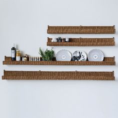 three wooden shelves with baskets and plates on them