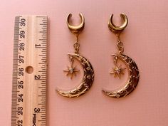 2g (6mm) - 1 3/16 (30mm) Gold Tone Crescent Moon & Star Saddles Drop Dangle Earrings Gauges/Earplugs Plugs.PLEASE read section regarding sizing before purchasing as due to sensitive nature of my products (body jewelry) as I cannot accept returns or exchanges. The details:-316L stainless steel saddle. -Features gold tone alloy crescent moon and 18k gold plated star with zircon center. -All earrings are assembled by hand and sold in pairs.-Available from 2g (6mm) to 30mm.-Each earring (not includi Celestial Star Jewelry For Festival, Celestial Star-shaped Festival Jewelry, Celestial Festival Star Jewelry, Adjustable Celestial Cartilage Earrings, Celestial Adjustable Body Jewelry For Gifts, Adjustable Celestial Style Body Jewelry For Gifts, Celestial Crescent Cartilage Earrings, Internally Threaded Crescent Piercings For Gift, Internally Threaded Crescent Piercings As A Gift