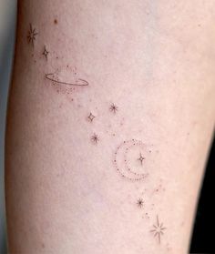 a woman's thigh with stars and a crescent tattoo