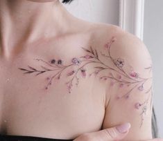 a woman's chest with flowers on it and her hand holding the breast piece