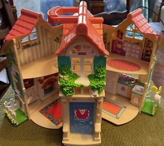 a toy house with lots of furniture and accessories on the table in front of it