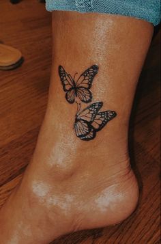 a woman's foot with a butterfly tattoo on the side of her left leg