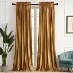 a living room filled with furniture and a large window covered in gold drapes