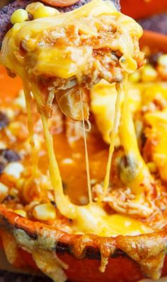 a cheesy baked potato is being lifted from the casserole dish