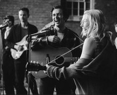 a group of people singing and playing guitars