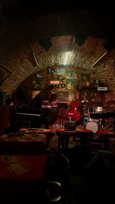 a room filled with lots of musical instruments and tables covered in red tablecloths