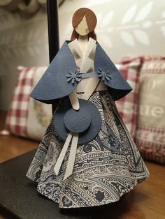 a paper doll sitting on top of a wooden table