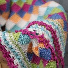 a crocheted blanket sitting on top of a wooden chair