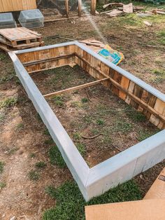 an unfinished raised garden bed in the middle of a yard