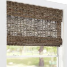 a close up of a window with a bamboo blind in the middle and an open window behind it