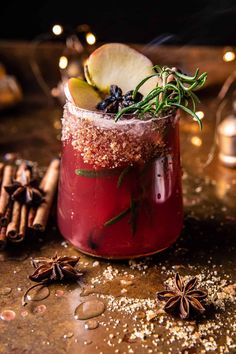 an apple cider cocktail with cinnamon, star anise and rosemary garnish