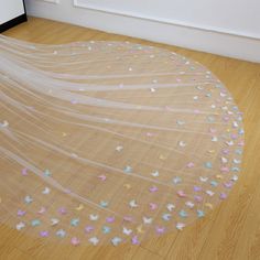 a veil with butterflies on it sitting on the floor in front of a wall and door