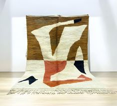 an old rug is on the floor in front of a white wall and wooden floors