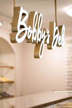 there is a sign that says bobby's bbq hanging from the ceiling