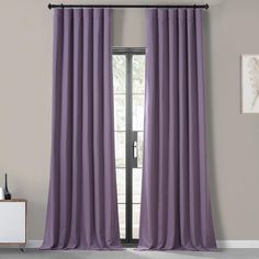 a living room with grey walls and purple curtains