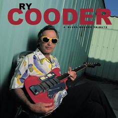 a man sitting in a chair holding a red guitar and wearing sunglasses with the caption, ray cooker