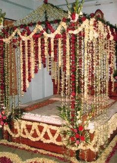 a bed covered in lots of flowers and greenery