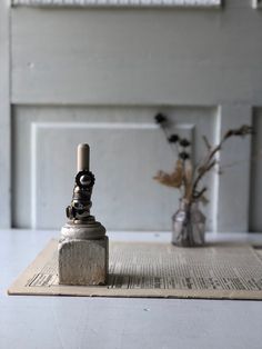 a vase with flowers in it sitting on top of a piece of paper