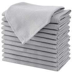 a stack of folded gray sheets on top of each other with a white pillow in the middle